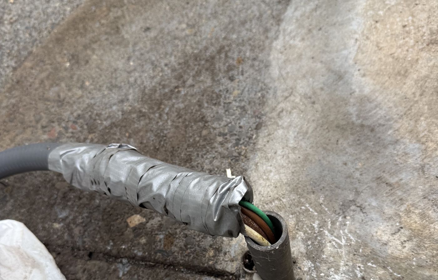 Damaged cord wrapped in duct tape with the inner conductors exposed