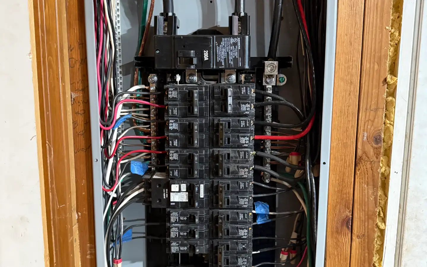 Open 200-amp Siemens main panel showing the main breaker and rows of branch circuit breakers